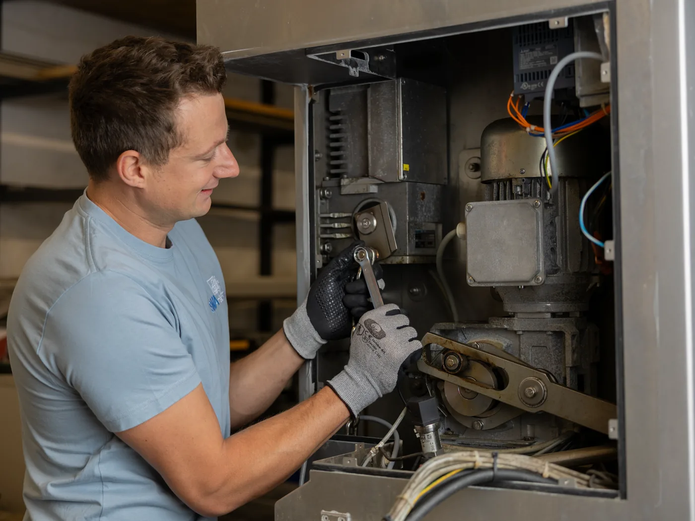 Reparatur im geöffneten Antriebsraum einer Maschine mit Motor und Riementrieb
